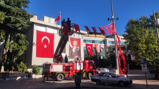 Turcy rozwieszają flagi państwowe na jednym z budynków publicznych