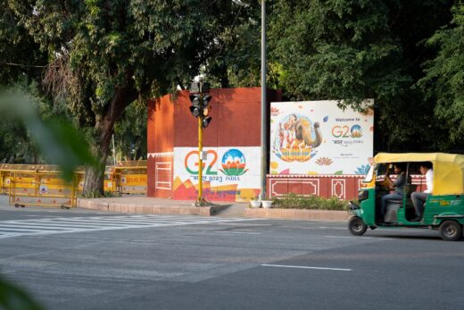 Autoriksza na ulicy Delhi. W tle billborad ogłaszający zjazd G20.