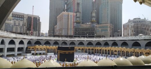 Mekka, Al-Kaba na tle miasta Mekka, modlący się tłum i nowoczesne miasto